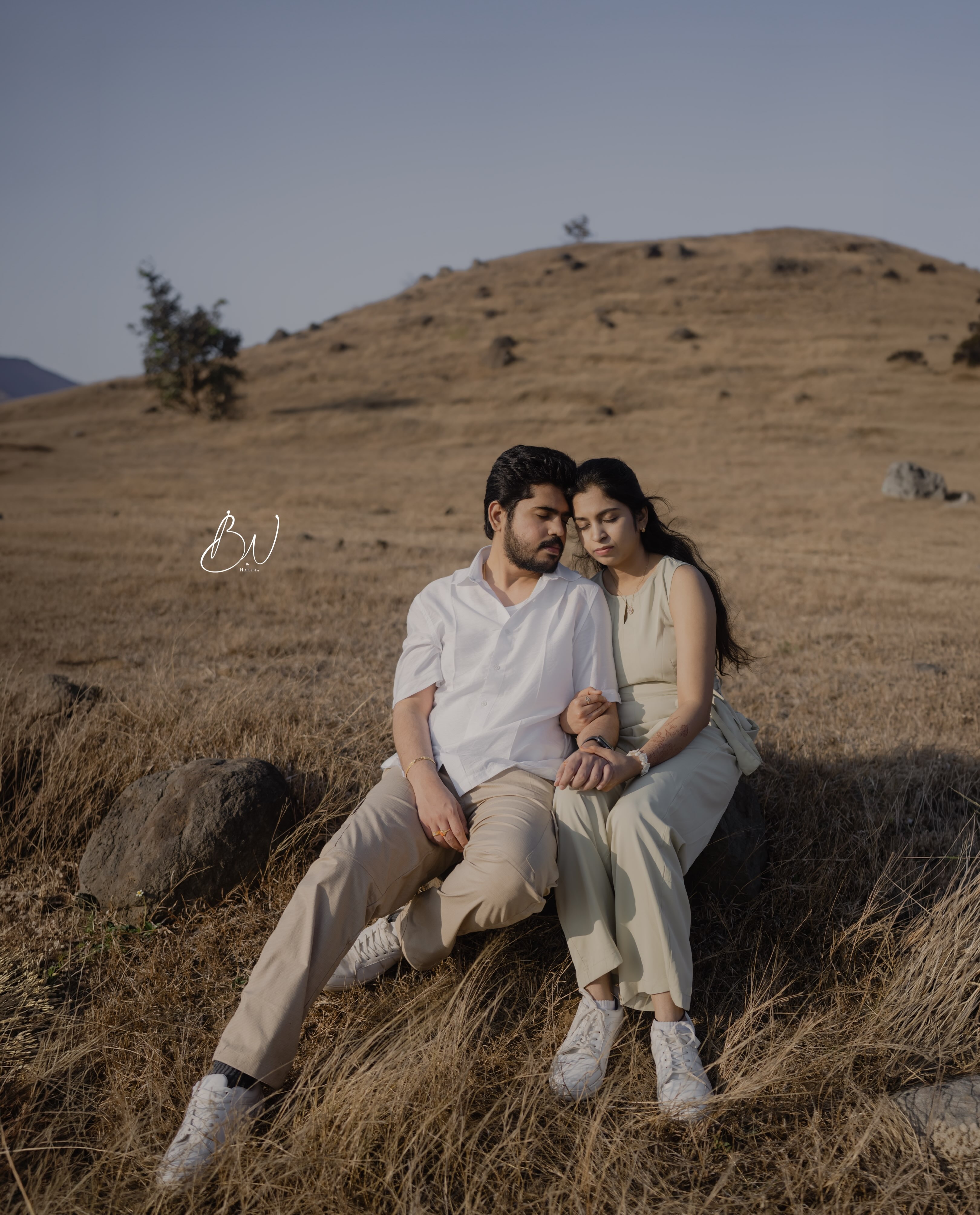 A couple sitting together in a softly lit outdoor setting